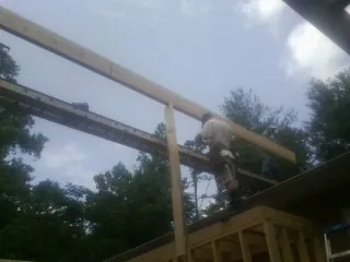 Carpenter setting a ridge beam over a new addition frame — Ice Dam Removal by Roofing Brothers in Matthews